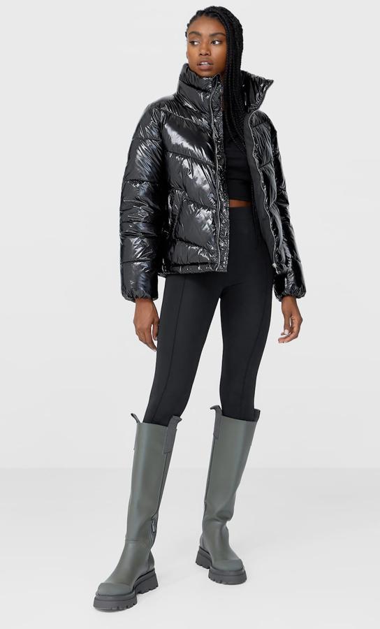 Esta cazadora acolchada con tejido efecto vinilo en color negro cuenta con bolsillos laterales con forro polar y cierre frontal con cremallera metálica. Es de Stradivarius y tiene un precio de 35,99 euros.