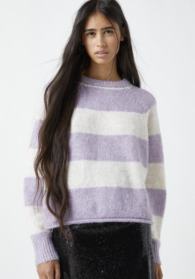 Este jersey cropped de color lila cuenta con escote en forma de pico y manga larga tipo raglán. En tejido ligeramente elástico, tiene un precio de 22,99 euros.