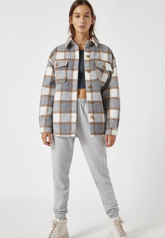 Esta sobrecamisa de cuadros en tono gris claro cuenta con forro acolchado y cierre mediante botones. Con detalle de bolsillos delanteros, tiene un precio de 35,99 euros.