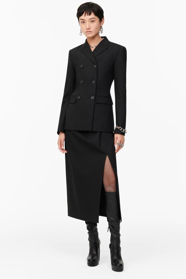 Un look sobrio y muy femenino, con chaqueta ceñida de doble botonadura y falda midi recta con apertura lateral, todo de Zara.