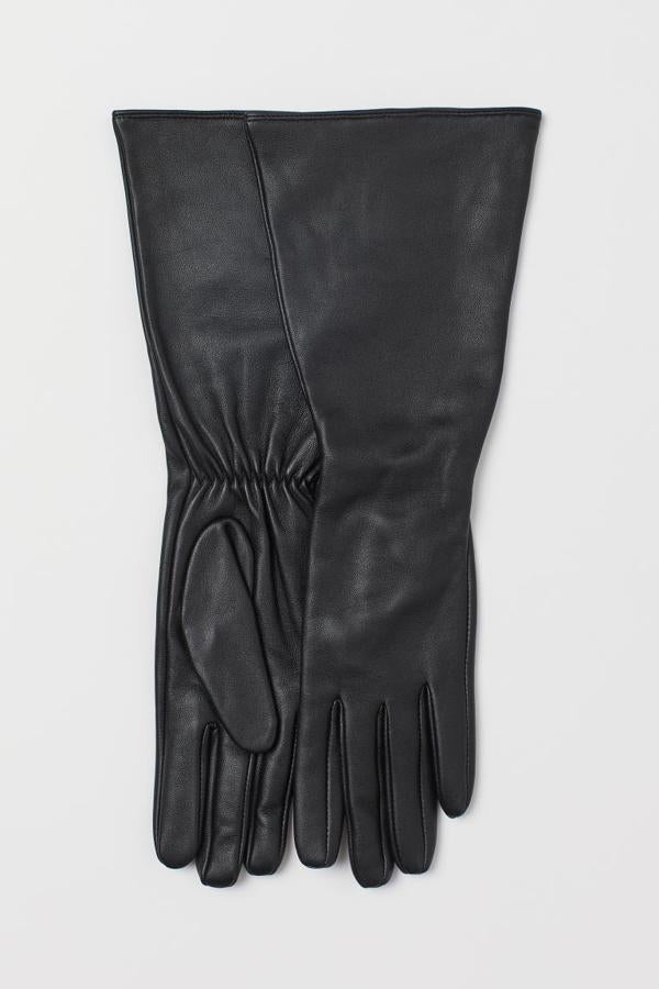 Diseño largo en piel suave con muñecas ligeramente amplias con elástico oculto para estos guantes negros de H&M que cuestan 34,99 euros y están disponibles entre las tallas XS y XL.