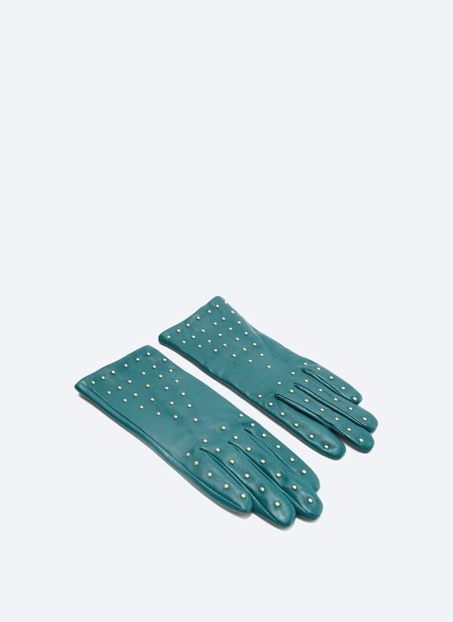 Con adornos de tallas doradas en el dorso de la mano, estos guantes en color petróleo confeccionados en piel de alta calidad son de Uterqüe y tienen un precio de 69 euros.