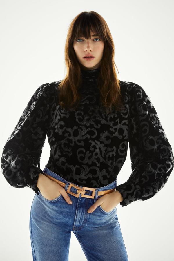 Cuerpo de terciopelo con manga larga abullonada y cuello alto, de Zara (29,95 €).
