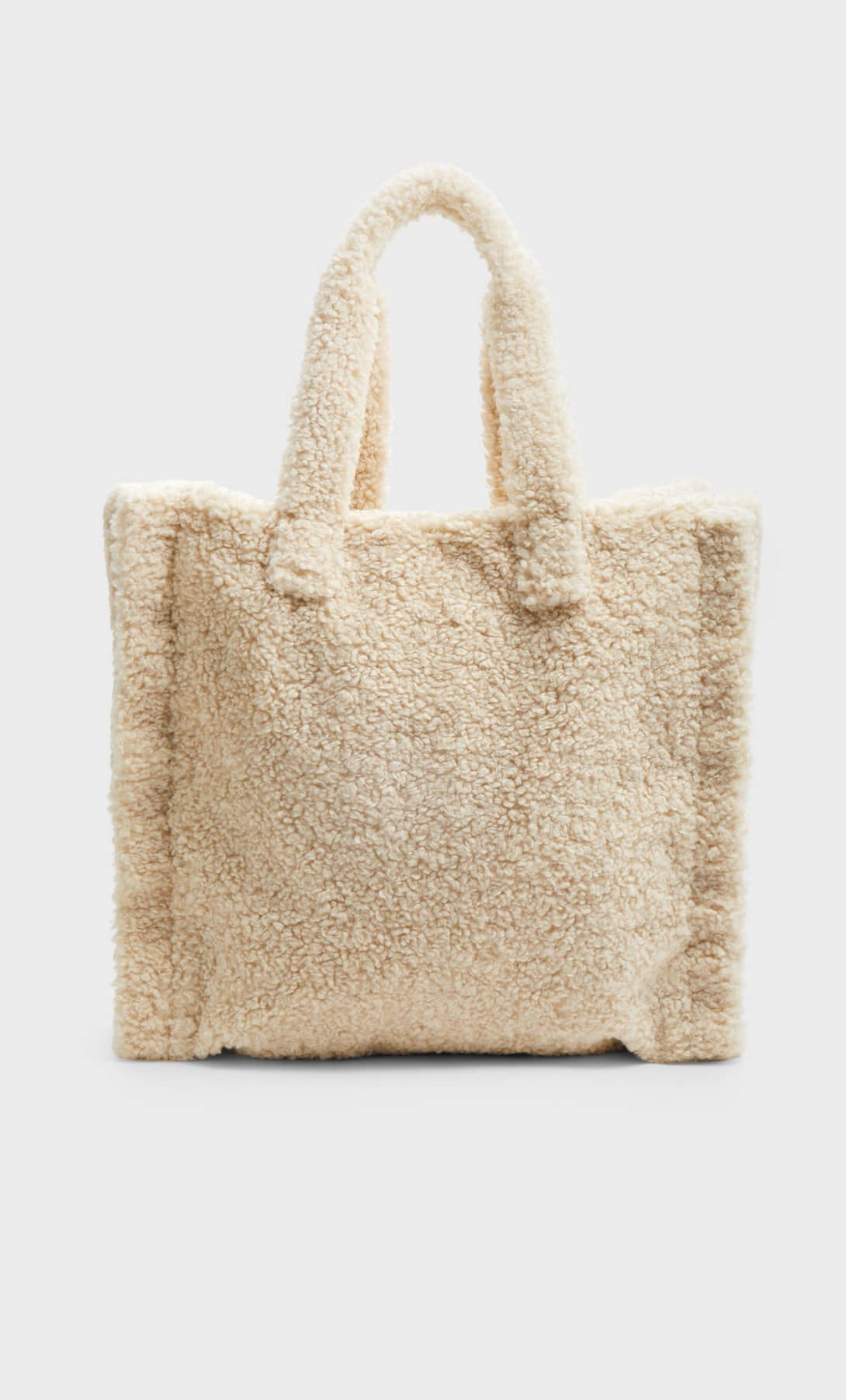 Bolso shopper de borreguito en tono crudo. Ahora: 15,99 euros.
