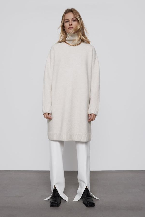 Look blanco total, con vestido de punto de cuello alto y pantalones rectos con aperturas en el bajo, todo de Zara.