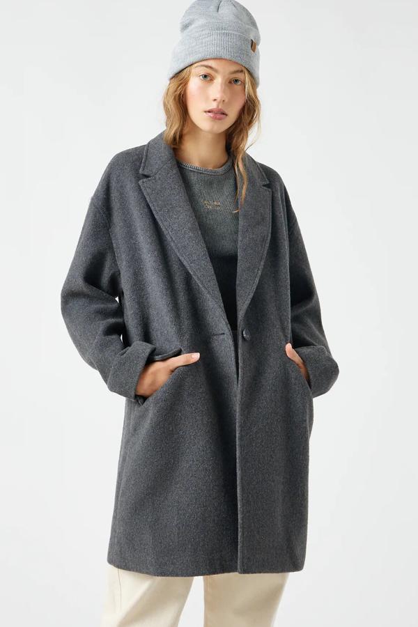 Este abrigo largo en color gris cuenta con cuello smoking y cierre de botón. Confeccionado en mezcla de lana, es de Pull & Bear y tiene un precio de 39,99 euros.