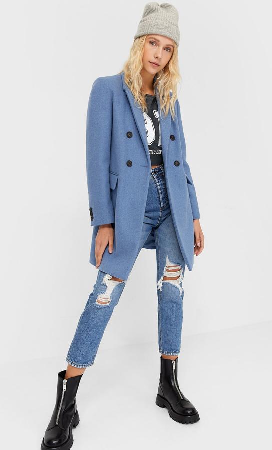 En color azul, este abrigo de paño con bolsillos delanteros con solapa y cierre con botón es de Stradivarius y tiene un precio de 49,99 euros.