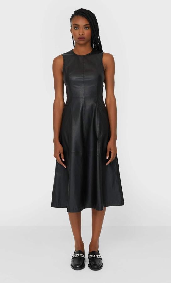 Este vestido midi en tejido de polipiel de color negro cuenta con cuello redondo y manga sisa. Disponible también en verde oliva, tiene un precio de 29,99 euros.