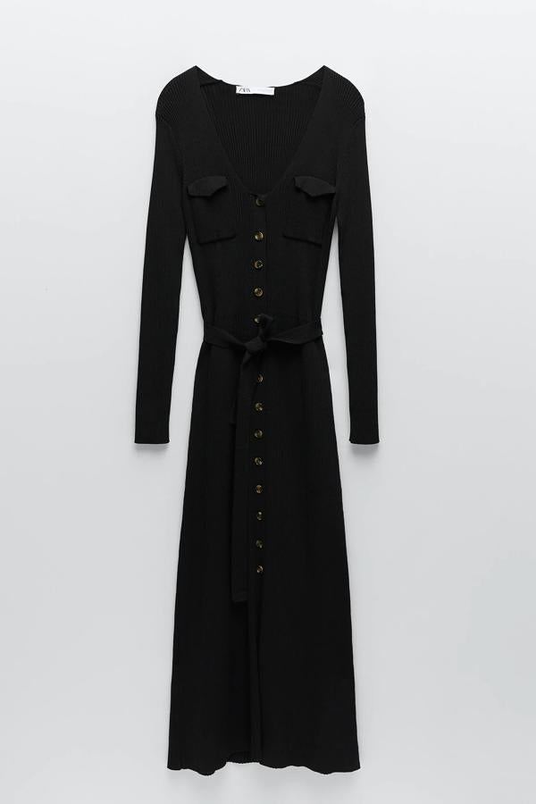 Este vestido largo de punto en color negro con escote de pico y bolsillos de plastrón con solapa cuenta con detalle de cinturón del mismo tejido y cierre frontal con botones. Tiene un precio de 49.95 euros.