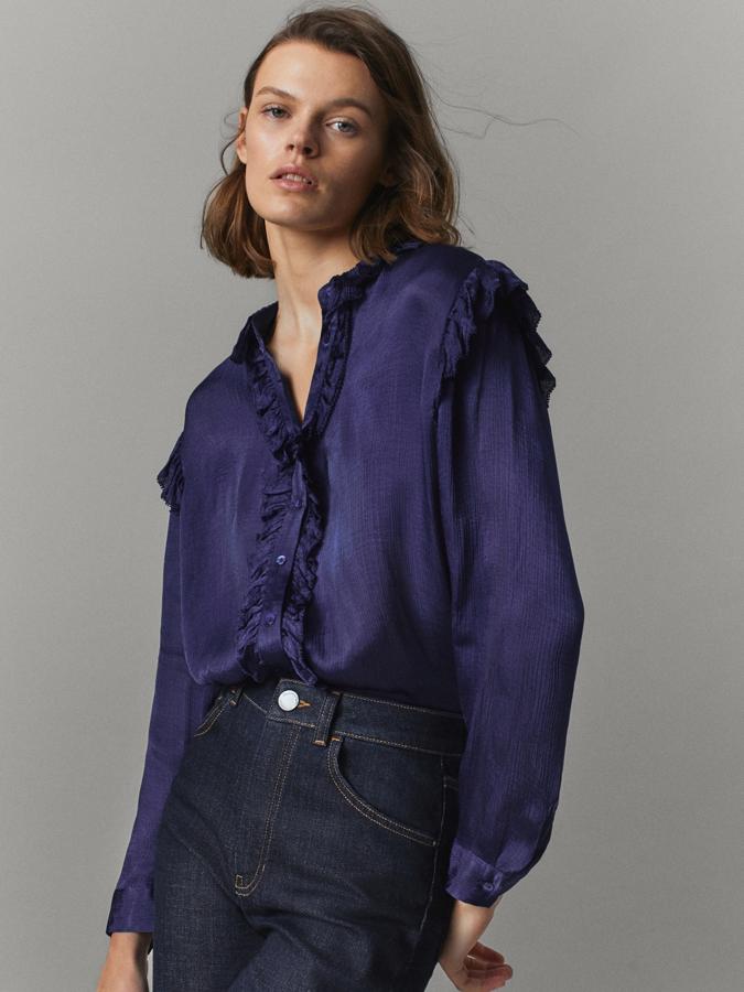 De corte recto y con cuello redondo, esta camisa satinada en morado azulado viene con volantes en el escote y los hombros y tiene la botonadura frontal a tono. De 49,95 euros ha pasado a 29,95 euros y está disponible entre las tallas 34 y 42.