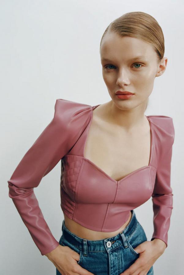 En efecto piel, con mangas largas abullonadas en los hombros y detalle de elásticos tipo nido de abeja en la espalda es de Zara y viene en un bonito rosa marsala. Tiene un precio de 22,95 euros y está disponible entre las tallas XS y L.