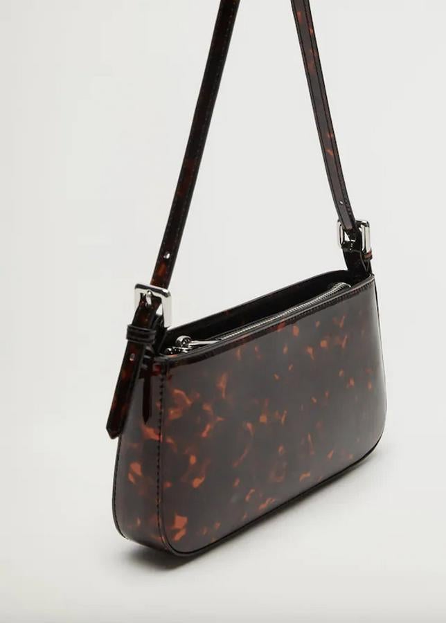 De venta exclusiva en la web de Mango, este bolso baguette en efecto carey viene con asa corta a tono y cierre de cremallera superior. Cuesta 15,99 euros.