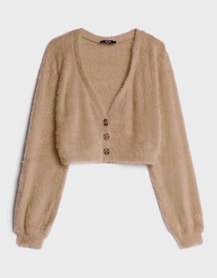 Disponible en camel, azul claro o fucsia, esta chaqueta de efecto pelo con botones tiene un precio de 17,99 euros.