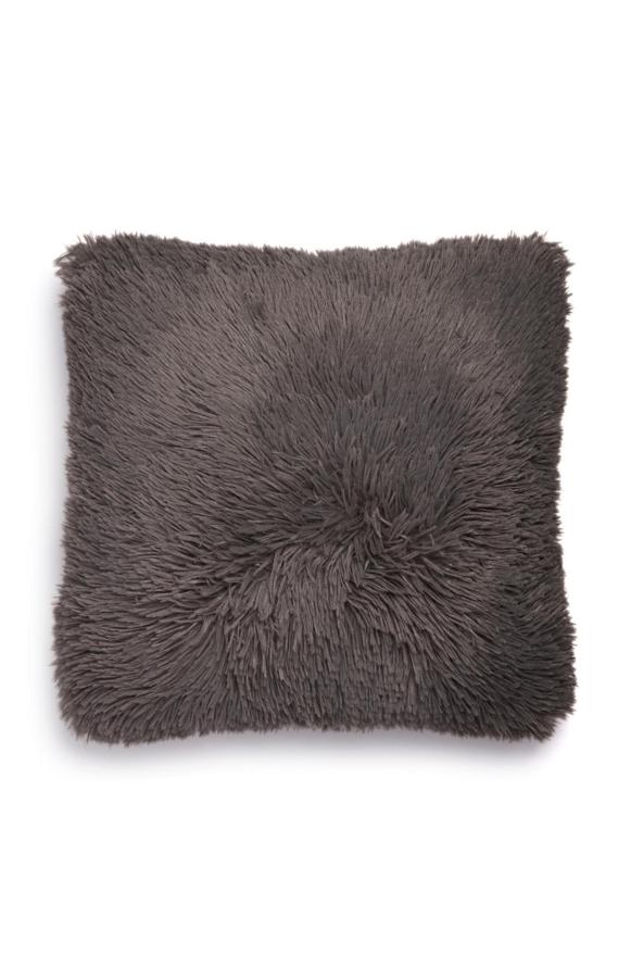 En color gris oscuro, este cojín cuadrado tipo pompón tiene un precio de 5 euros.