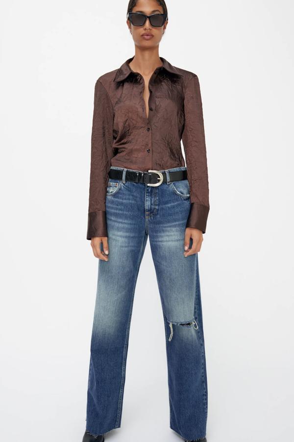 De tiro medio y con pernera ancha, estos jeans azules de efecto lavado y detalle de rotos cuentan con bajo acabado sin costuras y tienen un precio rebajado de 15,99 euros. Son de Zara.