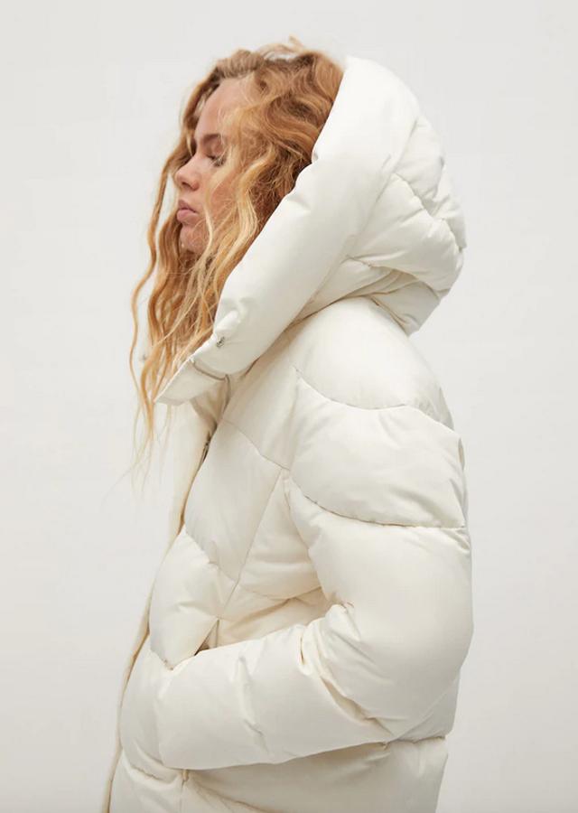 Disponible en blanco roto, beige, azul y negro, este anorak de plumón de Mango está confeccionado en tejido resistente al agua y tiene el diseño acolchado, el cuello chimenea y dos bolsillos laterales. Cuesta 69,99 euros y en blanco solo queda en las tallas L y XL.