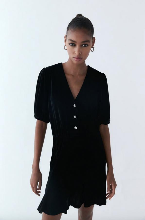 Con escote de pico y manga corta, este vestido de terciopelo de Zara con cierre frontal de botones joya tiene cintura elástica y bajo acabado en evasé. Cuesta 29,95 euros y está disponible entre las tallas XS y XXL