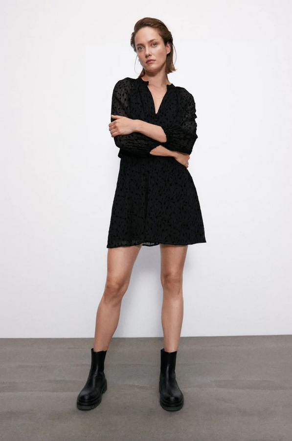 De cuello redondo, con escote de pico y manga larga abullonada acabada en punto, este vestido mini de Zara está confeccionado en tejido semitransparente con aplicaciones en terciopelo a tono. Con cintura elástica y forro interior, tiene un precio de 29,95 euros y está disponible entre las tallas XS y XL.