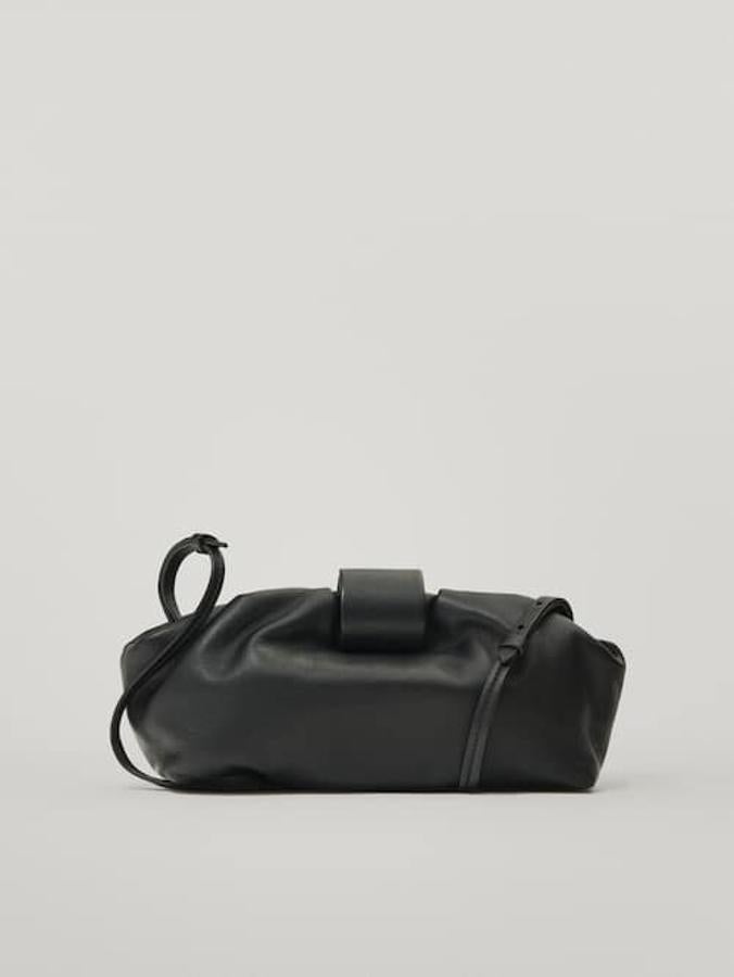 Confeccionado en piel ovina, con correa de hombro ajustable, este pouch podemos encontrarlo en negro, verde y burdeos y tiene cierre de imán oculto. Cuesta 79,95 euros.