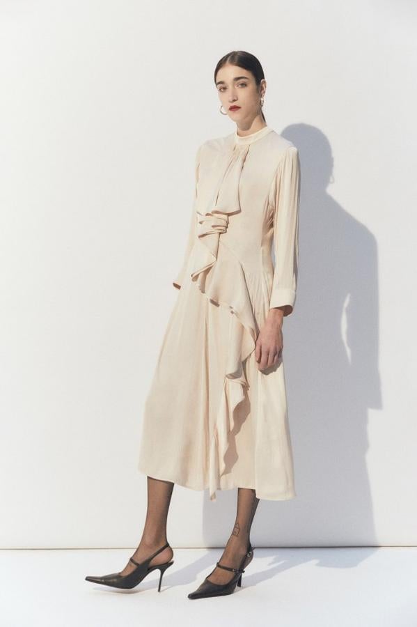 En beige claro, con volantes que van desde el escote hasta el bajo que queda por debajo de la rodilla, este vestido satinado de cuello redondo y manga larga está disponible en las tallas S y M y cuesta 49,99 euros.