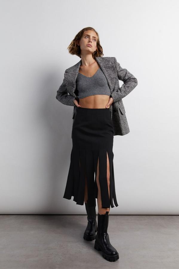 Diseño midi con detalle de tablas tipo flecos para esta falda negra con cierre lateral de cremallera que tiene un precio de 39,99 euros y está disponible en las tallas S, M y L.