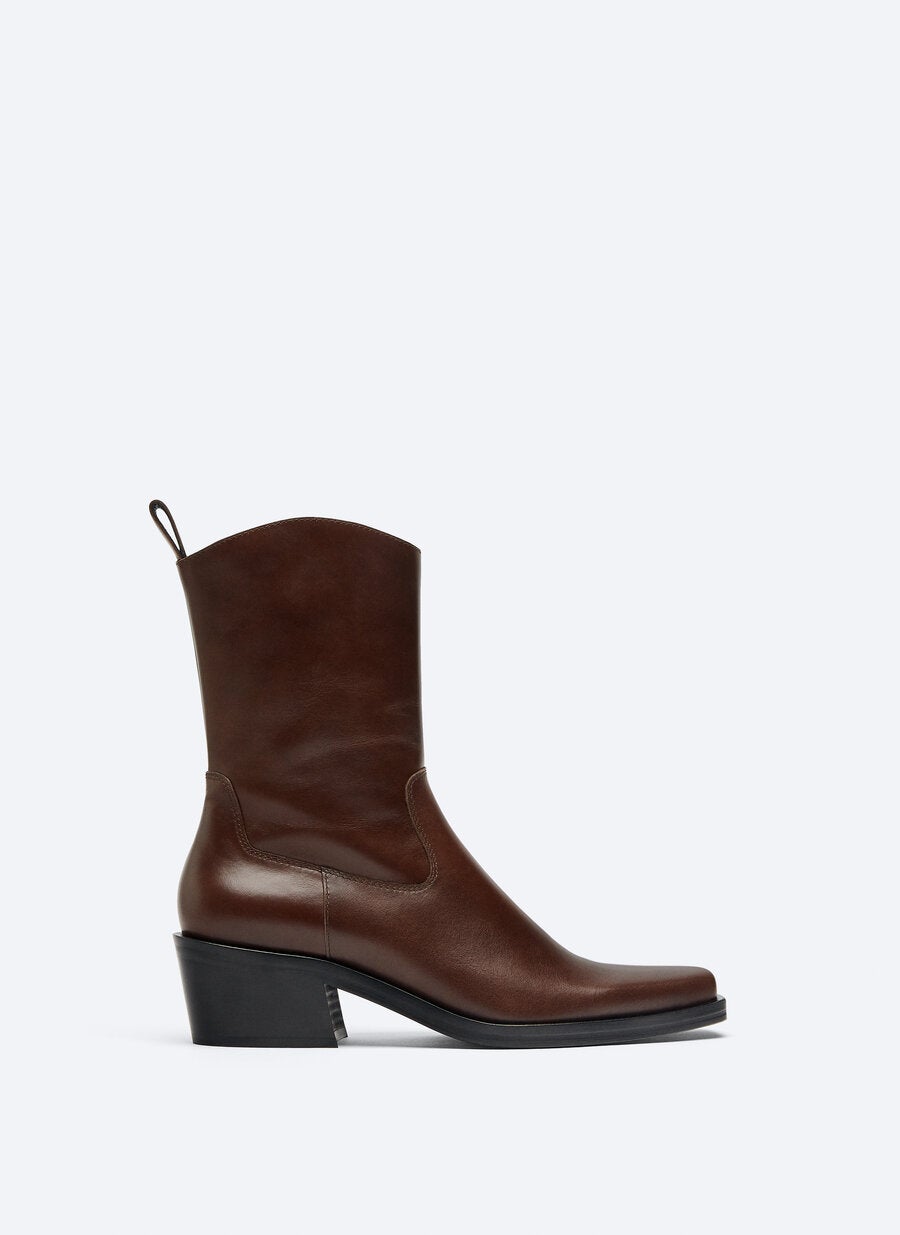 Botas cow boy en marrón oscuro para looks de máxima tendencia. (129 euros).