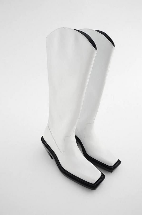 Diseño alto con tacón cowboy geométrico para estas botas altas de Zara en color blanco con corte de piel, acabado en punta cuadrada y suela a contraste en negro. Cuestan 139 euros y están disponibles entre los números 35 y 41.