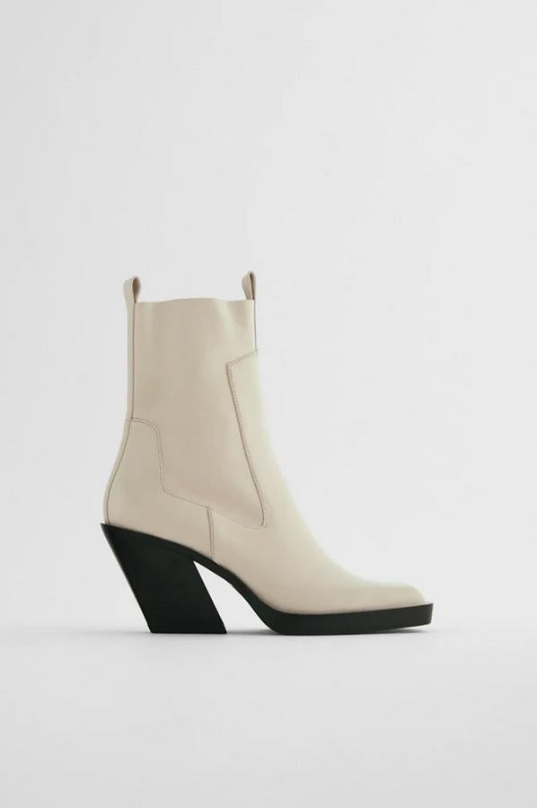 Estos botines de tacón de de Zara en piel blanca cruda vienen con corte de piel, cierre interior de cremallera y tacón cowboy en contraste. Acabado en punta cuadrada y con tirador trasero y delantero, tienen un precio de 69,95 euros y está disponible entre los números 35 y 42.