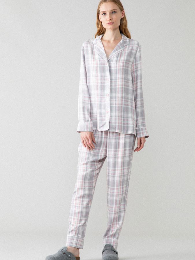 Con estampado de cuadros en blanco y rosa, este pijama de camisa con solapa y abertura delantera con botones y pantalón largo ajustable tiene un precio de 12,99 euros.