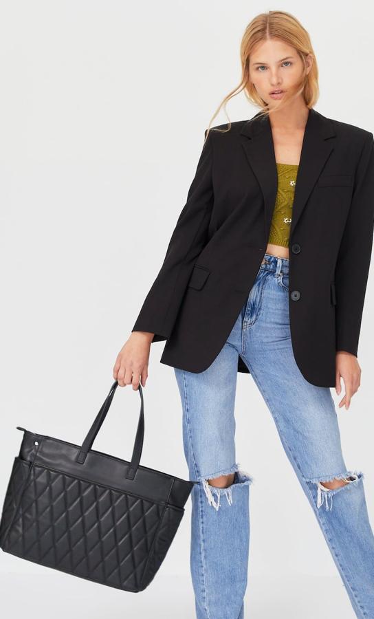 Este bolso shopper acolchado en color negro cuenta con asas de mano y asa de hombro extraíble. Es de Stradivarius y tiene un precio de 19,99 euros.