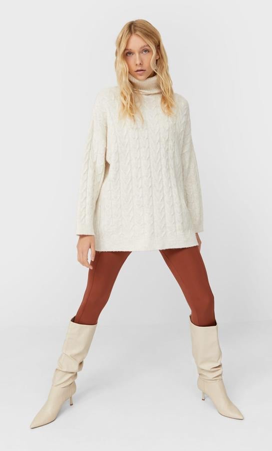 Disponible en color piedra, gris o negro, este jersey oversize de punto en trenzas y con cuello cisne es de Stradivarius y tiene un precio de 25,99 euros.