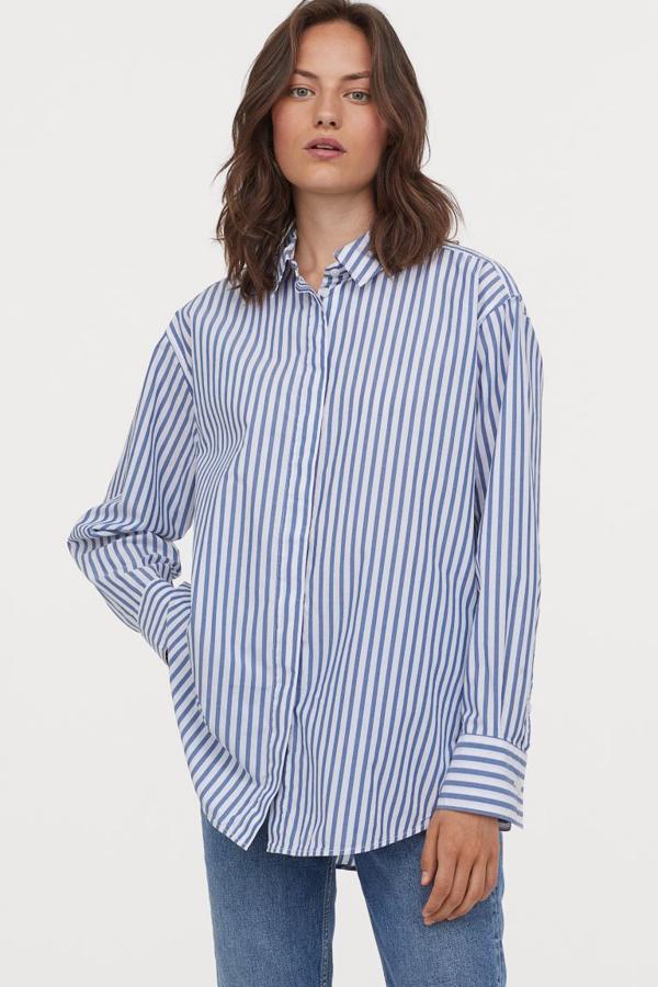 Con rayas en color blanco y azul intenso, esta camisa oversize de H&M en algodón, con cuello clásico, canesú con pliegue en la espalda para dar volumen y diseño de hombros caídos tiene un precio de 19,99 euros y está disponible entre las tallas XS y L.