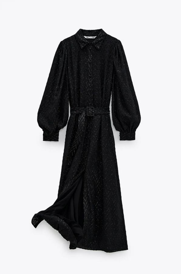 Diseño midi para este vestido negro con cuello de solapa y manga larga abullonada acabada en puño. Viene con cinturón a tono con hebilla forrada y tiene un precio de 59,95 euros. Con cierre frontal con botones forrados, está disponible entre las tallas XS y XXL.