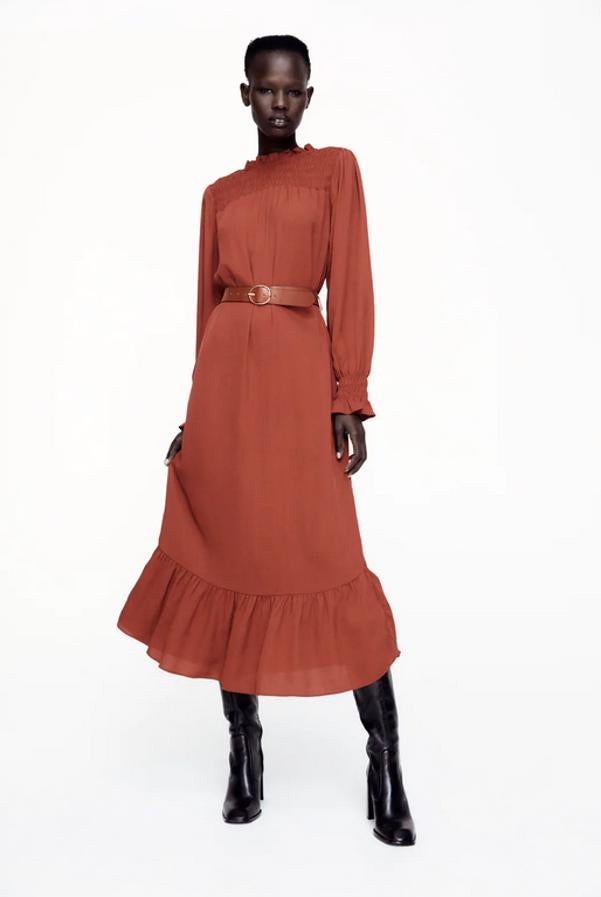 De cuello redondo y manga larga, este vestido largo en color teja viene con detalle de acabados con volantes y elásticos tipo nido de abeja en la parte superior del frontal. Con cinturón combinado a tono en piel y con hebilla metálica, cuesta 39,95 euros y está disponible entre las tallas XS y L.