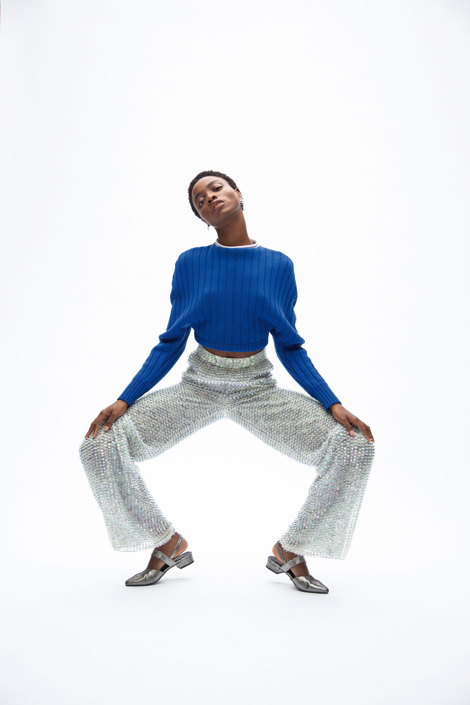 Jersey de Versace, pantalón de Giorgio Armani, zapatos de Fórmula Joven en El Corte Inglés y pendientes de Pomellato.