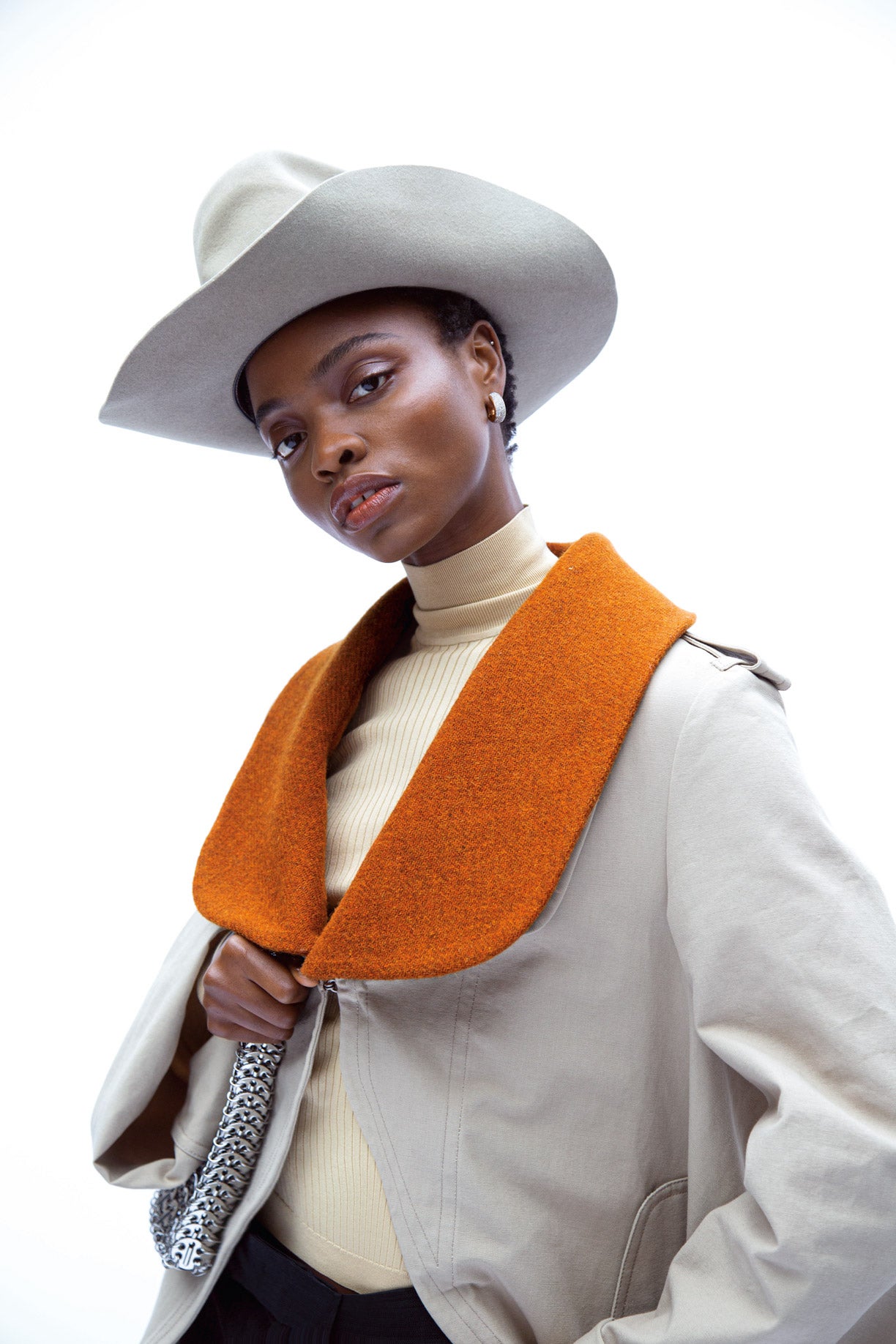 Chaqueta de napa con cuello de lana, de Loewe; y jersey de cuello alto, de Hermès. Pendientes de Pomellato y sombrero de fieltro, de Stetson.