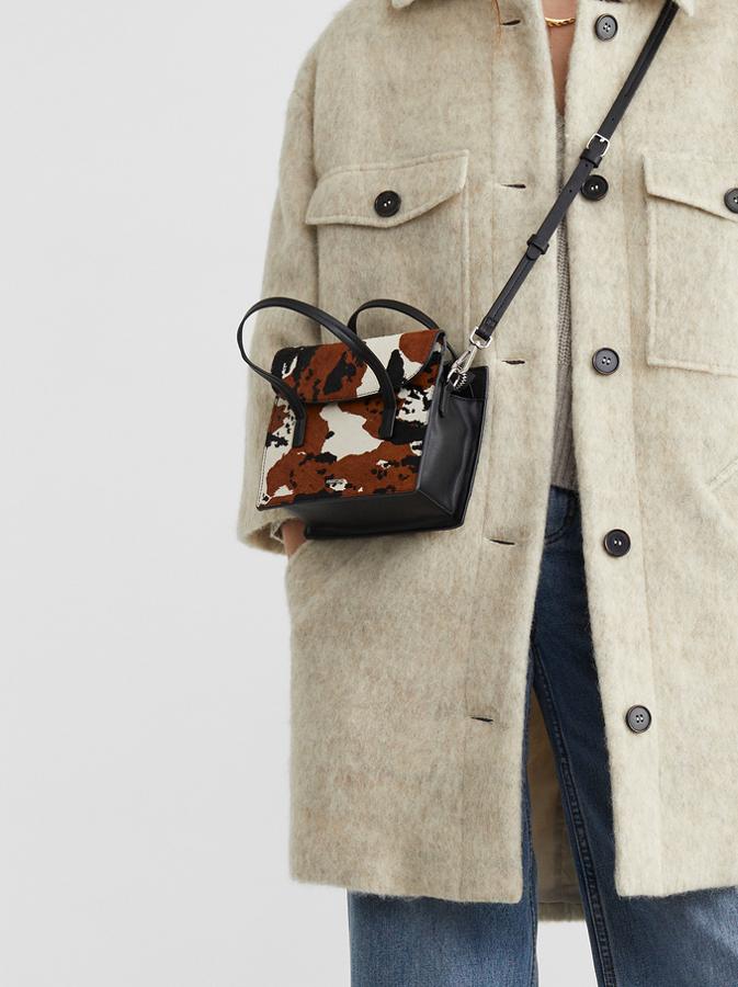 Tonos blancos, negros y marrón en piel para este bolso de mano de base negra con asas de mano y de hombro a tono. Costaba 25,99 euros y ahora podemos encontrarlo por 20,79 euros.