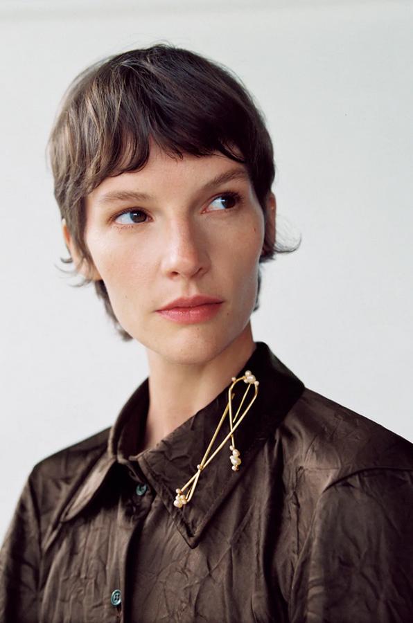 Diseño metálico fino con detalles de perlas naturales para este broche dorado de Zara que cuesta 9,95 euros.