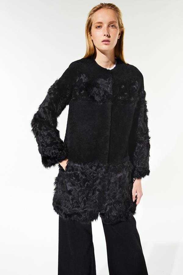 Cuello redondo y color negro para este abrigo midi de piel de cordero en pelo y patch de contraste de tejido en la zona central. De 199,99 euros ha pasado a costar 139,95 euros y está disponible en las tallas S, M y L.