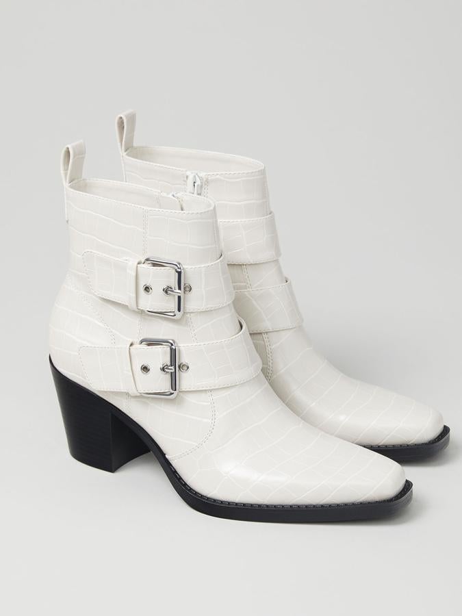 En color blanco roto, este botín con tacón de 6,5 centímetros y textura coco cuenta con tirador en la parte trasera y detalle de hebillas. Tiene un precio de 29,99 euros.