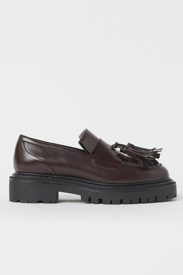 Con suela ancha y borlas en tamaño XL, estos mocasines son de H&M y combinan dos tonos, el negro en la suela y el marrón en el zapato (34,99 euros).