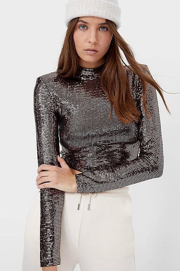 De manga larga y cuello perkings, esta camiseta corta con hombreras y abertura en la espalda es de lo más favorecedora.