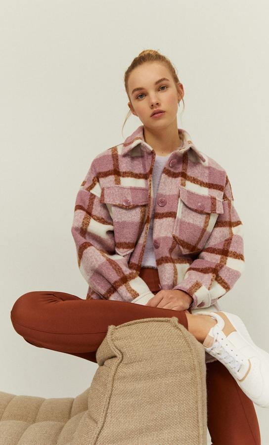 Con cuello solapa y bolsillos delanteros con solapa, esta sobrecamisa de Stradivarius con cierre frontal de botones y bolsillos ocultos en la costura viene en color malva con cuadros en marrón. Cuesta 39,99 euros y está disponible en las tallas XS, S y M.