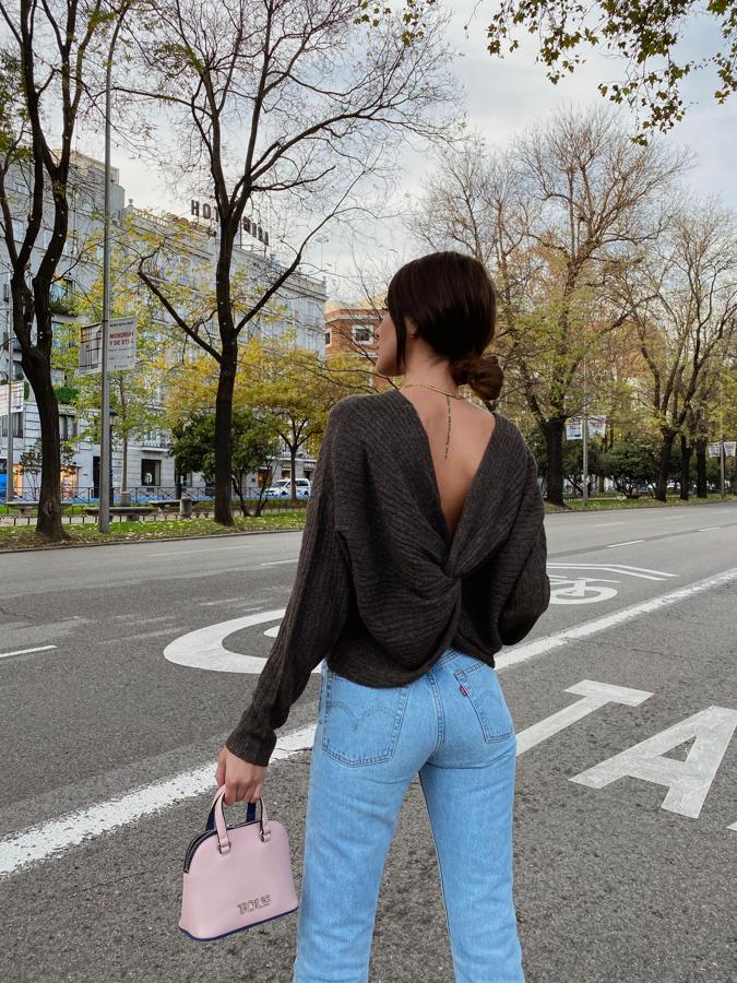 ¿Quién dijo que un jersey de punto no podía ser una de las prendas más sexys de nuestro armario? Mery Turiel lo demuestra con este diseño en punto gris con escote a la espalda de Pieces ( a la venta en Amazon ), que combina con  unos Levi's de cintura marcada que estilizan  la silueta. El toque 'naive' lo da el  mini bolso de Tous  en rosa cuarzo, uno de los colores de la temporada.