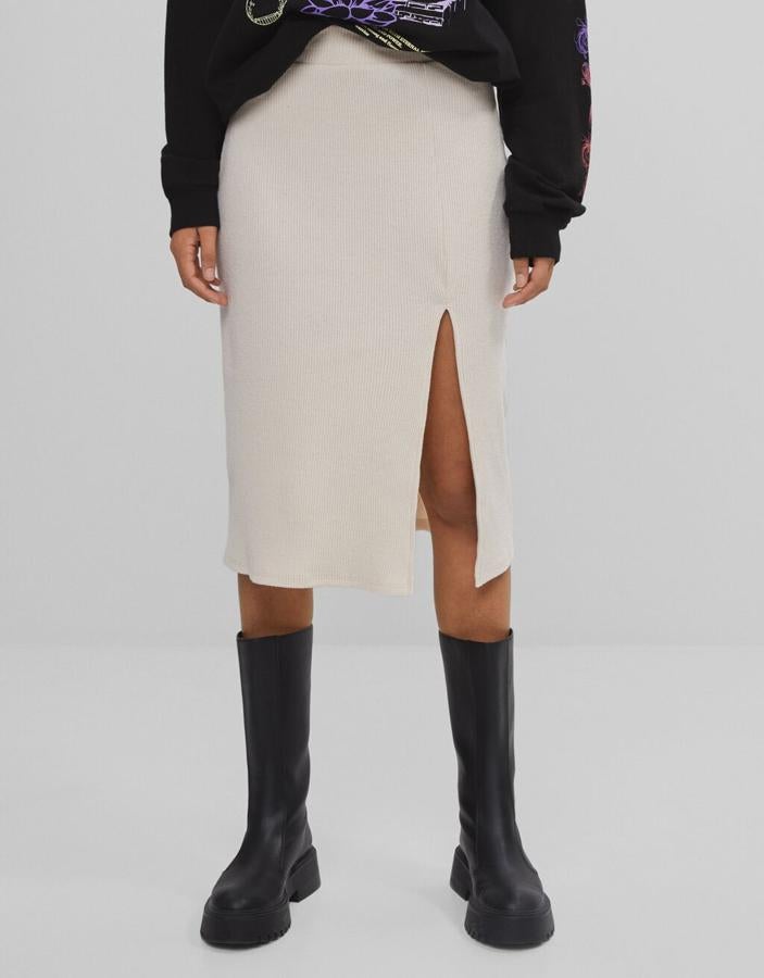 En color arena, confeccionada en tejido elástico y con abertura lateral en el bajo, esta falda midi de Bershka costaba 15,99 euros y ahora podemos comprarla en las tallas S, M y L por 9,59 euros.