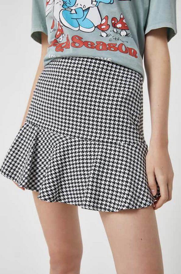 Pull&Bear ha llevado a esta falda pantalón con volante en el bajo el estampado tendencia, la pata de gallo. Confeccionada en tejido ligeramente elástico en blanco y negro, costaba 17,99 euros y ahora podemos comprarla por 12,59 euros entre las tallas XS y XL.
