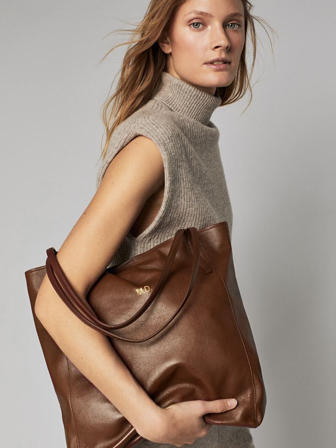 Confeccionado en piel bovina, con asa de hombro ancha a tono y cierre mediante imán oculto, este bolso de Massimo Dutti disponible en beige, cuero y negro, es personalizable y tiene un precio de 99,95 euros.