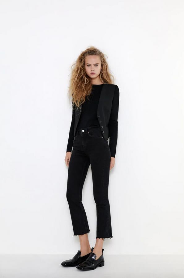 De tiro medio y diseño cropped, este pantalón vaquero negro confeccionado con al menos un 95 % de algodón orgánico tiene el bajo acampanado con acabado deshilachado, cinco bolsillos y cierre frontal de botón metalizado y cremallera. Disponible entre las tallas 32 y 46, cuesta 19,95 euros.