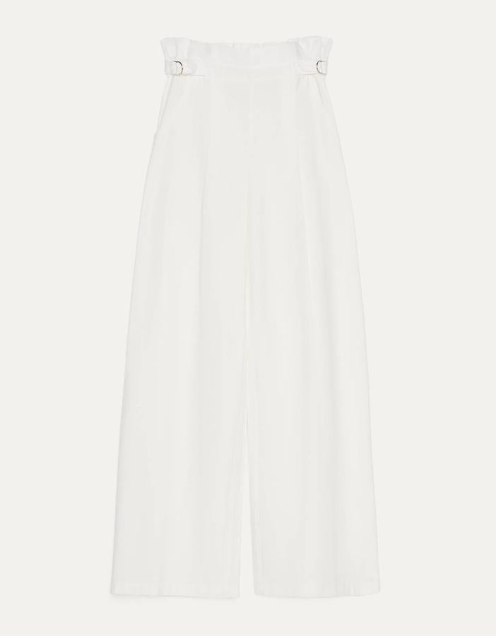 Este pantalón blanco con pierna ancha con aberturas en el bajo cuenta con detalle de pinzas y de hebillas en los laterales. Es de Bershka y tiene un precio de 22,99 euros.