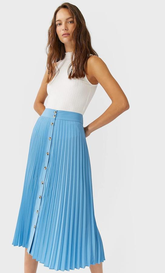 Disponible en azul, beige o negro, esta falda midi plisada con cierre mediante botonadura frontal y elástico en la cintura es de Stradivarius y tiene un precio de 19,99 euros.